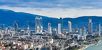 İzmir şehir manzarası, modern binalar ve doğa ile birleşiyor.