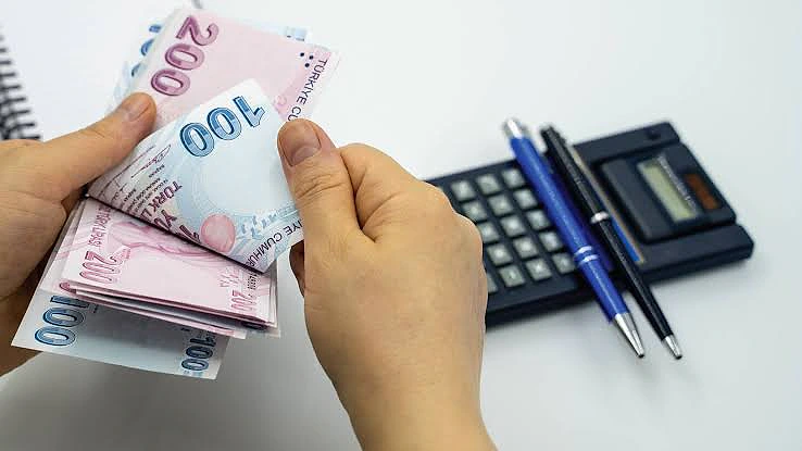 Hesap makinesi ve para ile işsizlik maaşı hesaplama süreci.