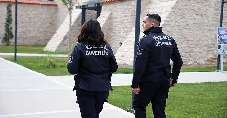 Özel güvenlik görevlileri, açık alanda yürüyüş yaparken dikkatli bir şekilde görevlerini yerine getiriyor.